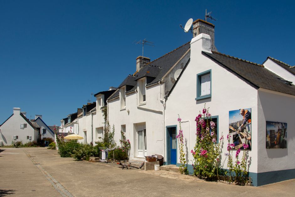 Quaint houses with flowers on a sunny day in a Breton village, perfect for travel and architecture themes.