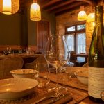A table setting with wine bottle and glasses.