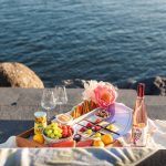 a tray of food sitting on top of a table next to a body of water